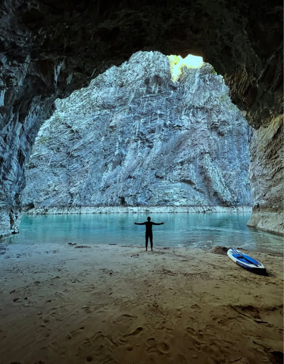 Cave opening beside the turquoise river