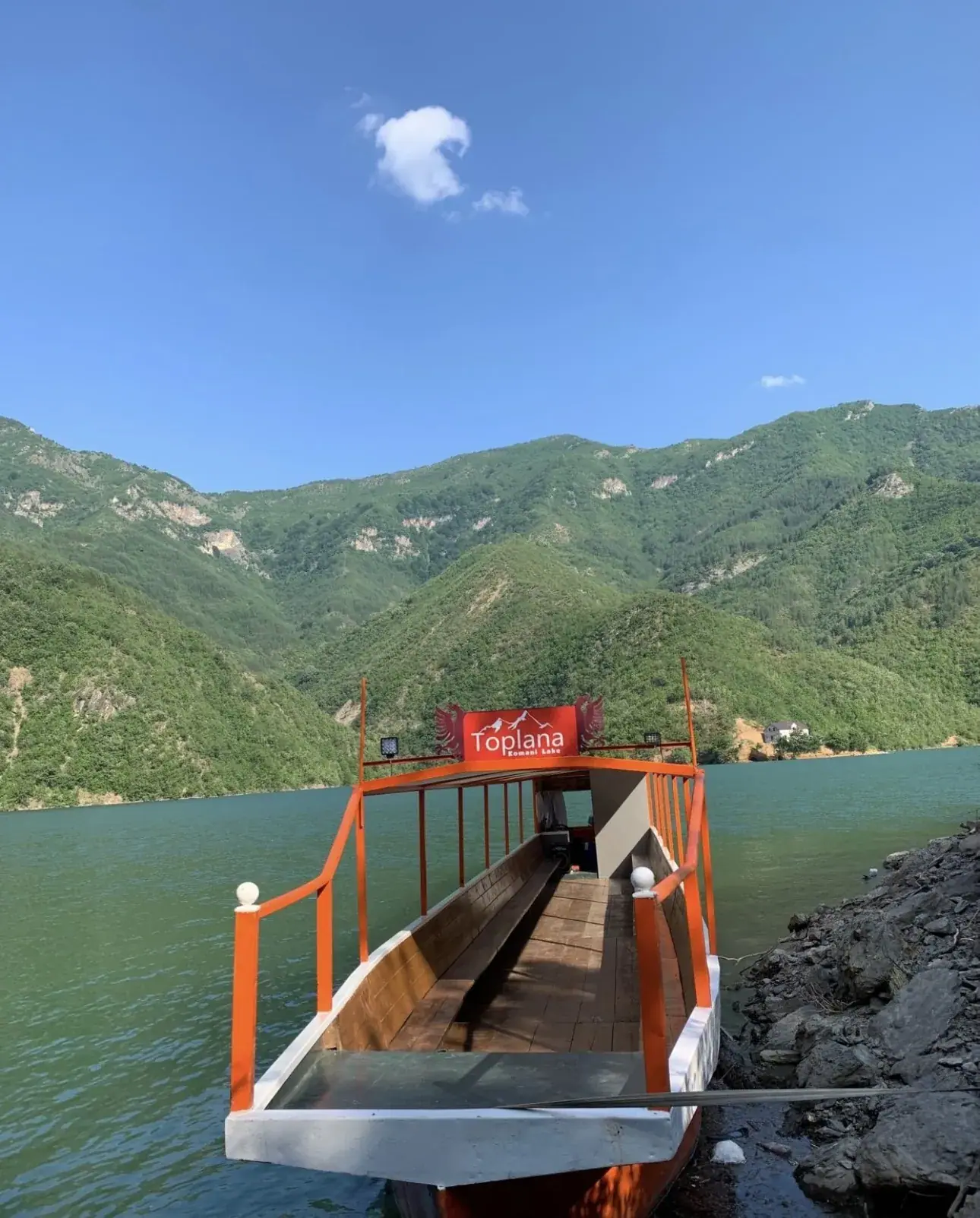 Orange Toplana boat sailing on the Shala River